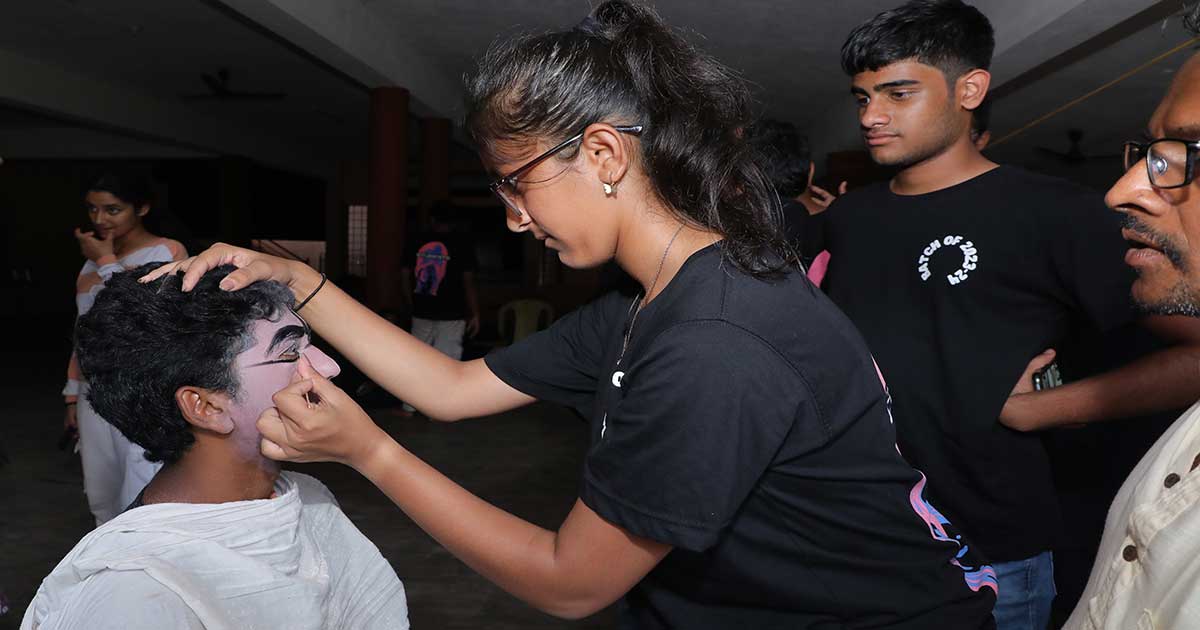 A girl applies face paint to another participant during the IBDP Year 2 CAS Trip 2023.