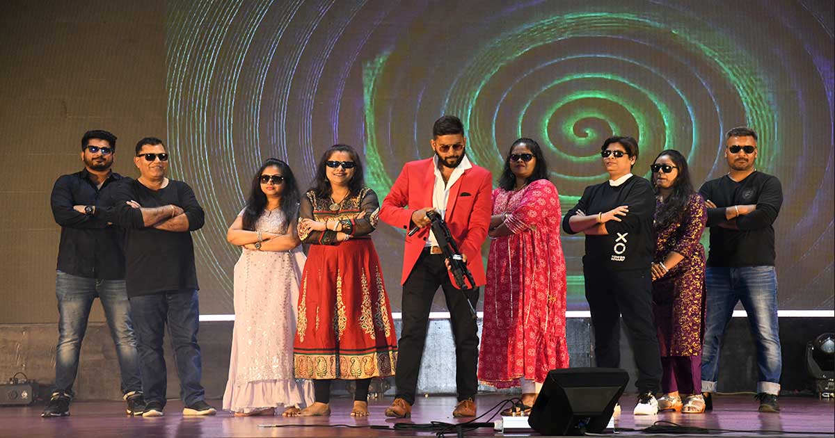 Eight individuals pose on stage with sunglasses during Children's Day 2023 Celebrations at JIRS.