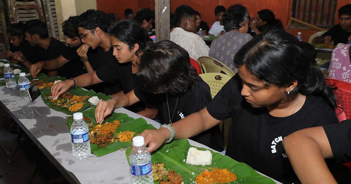 Young individuals enjoying a communal meal on banana leaves during the IBDP Year 2 CAS Trip 2023.